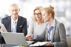 Two people going over estate planning documents; A Living Trust Has Some Big Benefits, But is It Right For You?